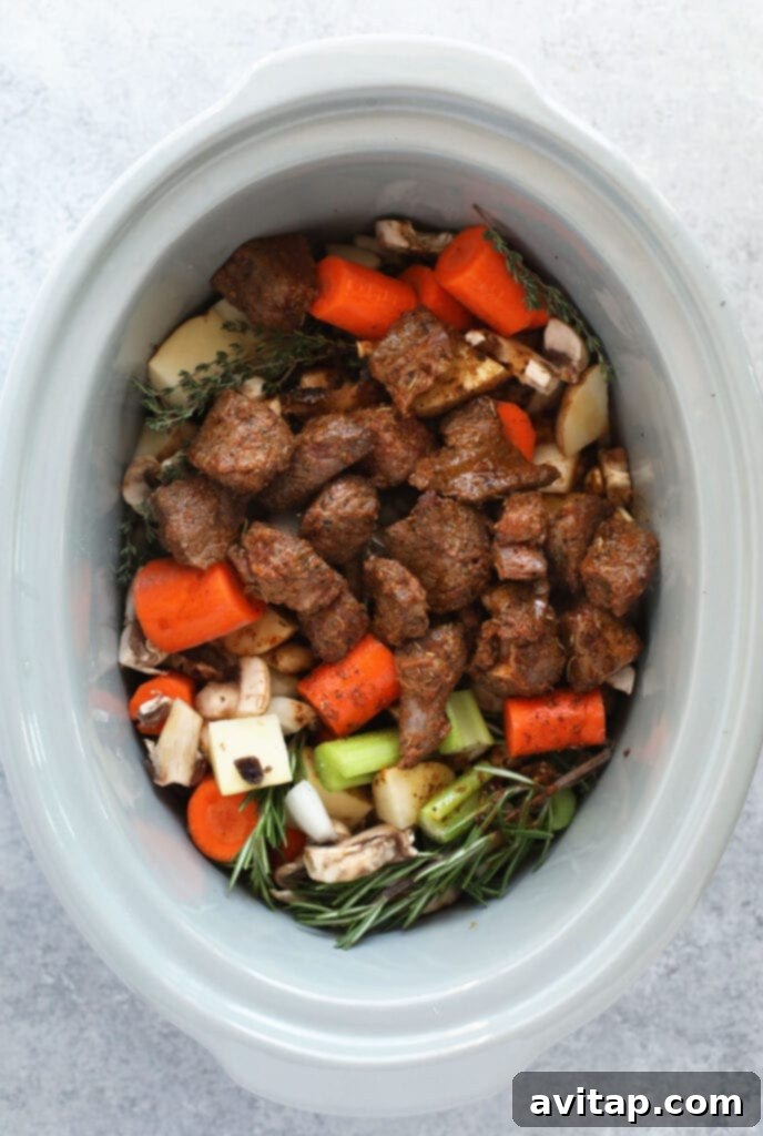 Fresh ingredients for beef stew, meticulously arranged and ready to be added to the slow cooker.