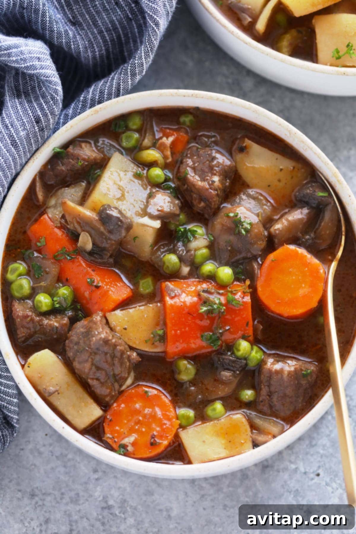 A beautiful bowl of slow cooker beef stew, garnished with fresh herbs, ready to be served and enjoyed.