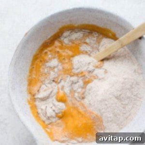 Pumpkin pancake batter in a bowl, showing a smooth but slightly lumpy consistency.