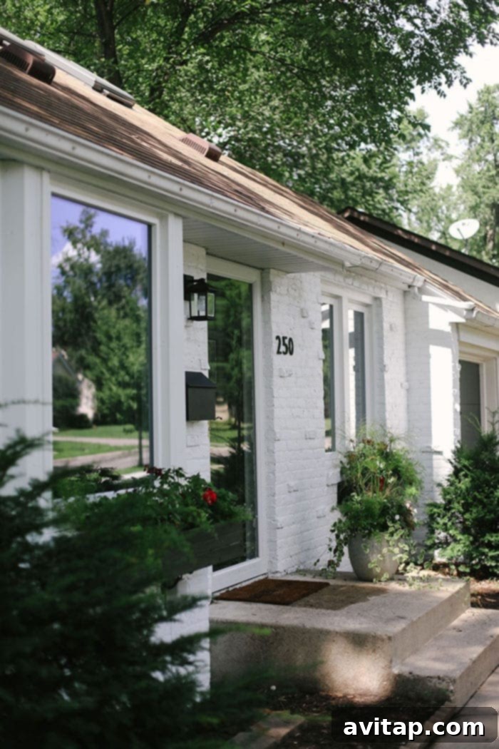White brick house featuring modern black house numbers