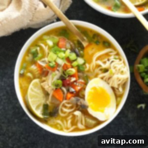 A vibrant, steaming bowl of Ramen Chicken Noodle Soup, elegantly garnished with fresh herbs and a perfectly soft-boiled egg, highlighting its rich textures and inviting colors.