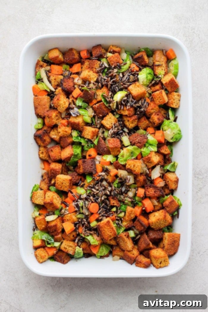 A close-up view of baked cornbread dressing in a large casserole dish, showing the golden-brown crust.
