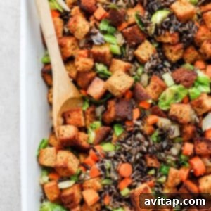 A close-up shot of a bowl of golden cornbread dressing, showcasing its rich texture and savory ingredients.