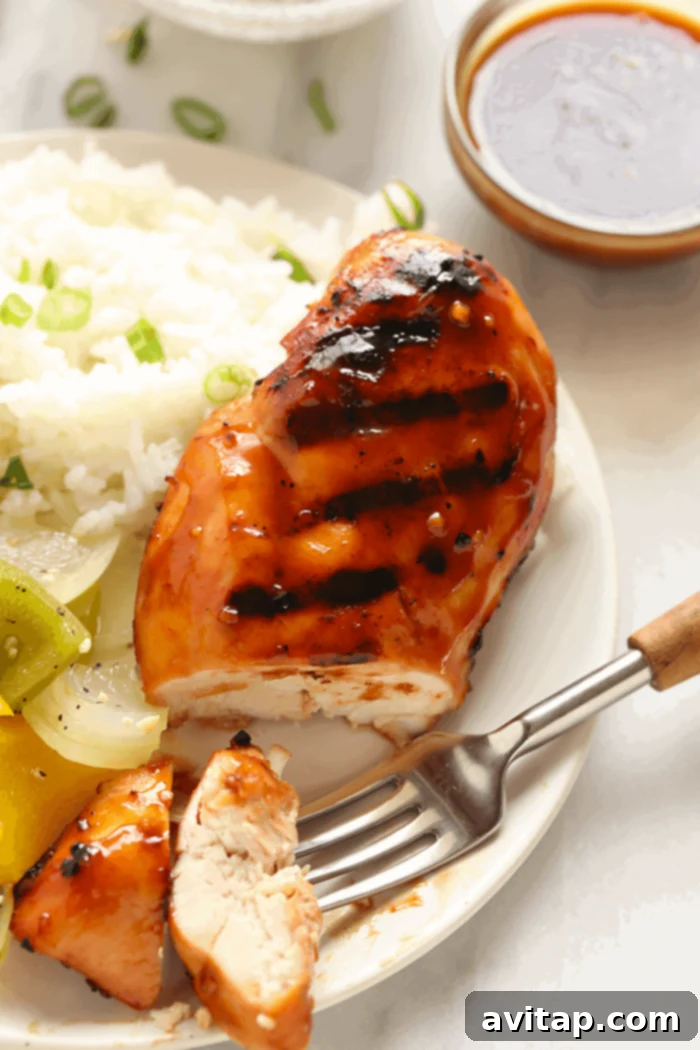 A sliced Teriyaki Chicken breast on a plate, garnished and ready to eat.