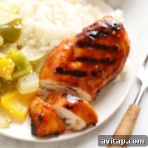 A plate with grilled chicken and vegetables on it.