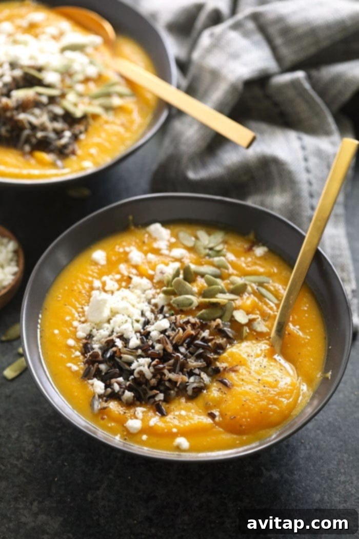 Instant Pot Butternut Squash Soup in a bowl, garnished with wild rice and crumbled goat cheese.