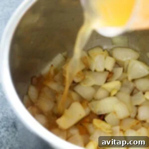 Vegetable broth being poured into Instant Pot with sautéed onions and garlic.
