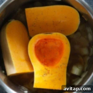 Quartered butternut squash and seasonings layered in the Instant Pot.