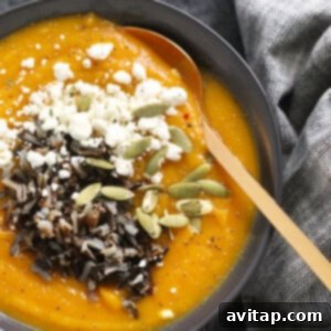 A finished bowl of butternut squash soup with seeds as a topping.