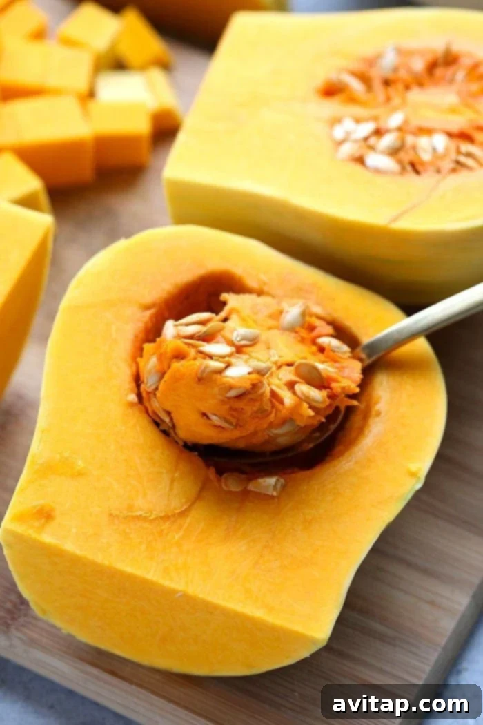 Butternut squash being cut on a wooden cutting board.