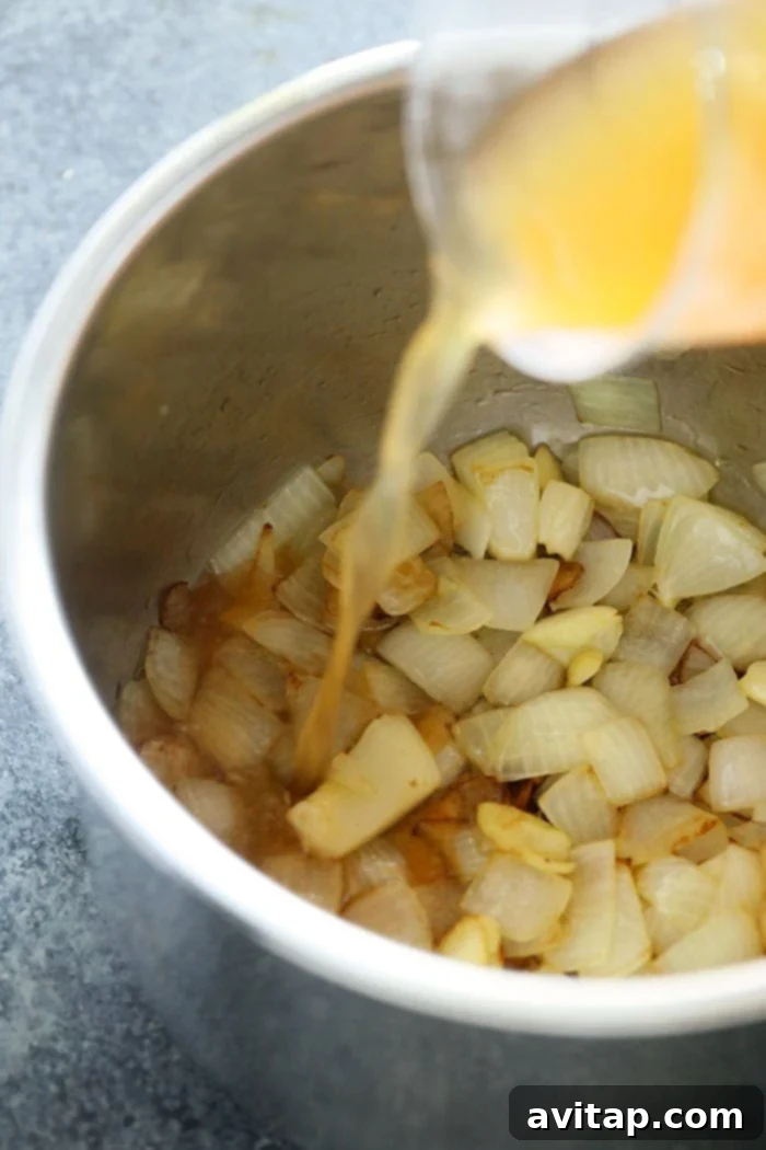 Sautéed onions and broth simmering in the Instant Pot liner.