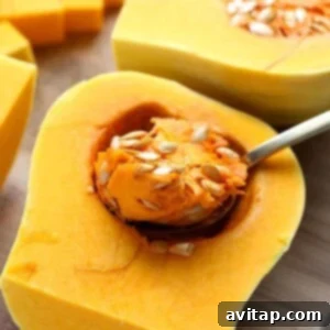 Cleaning out butternut squash seeds with a spoon.
