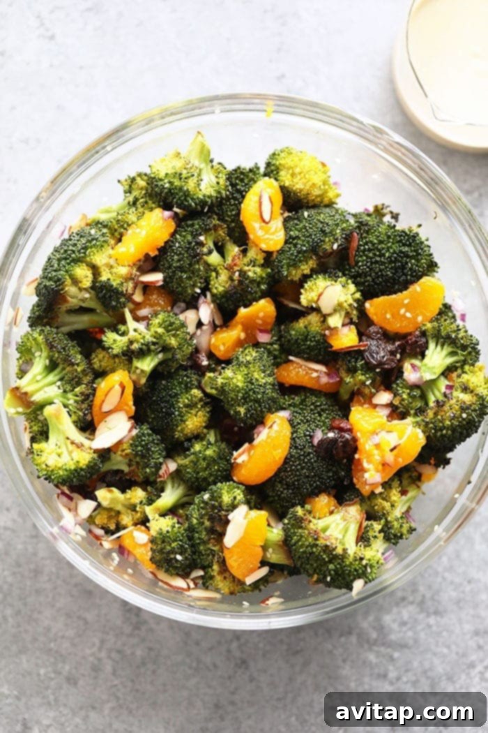 A serving of Vegan Mandarin Orange Broccoli Salad in a white bowl, ready to be enjoyed.