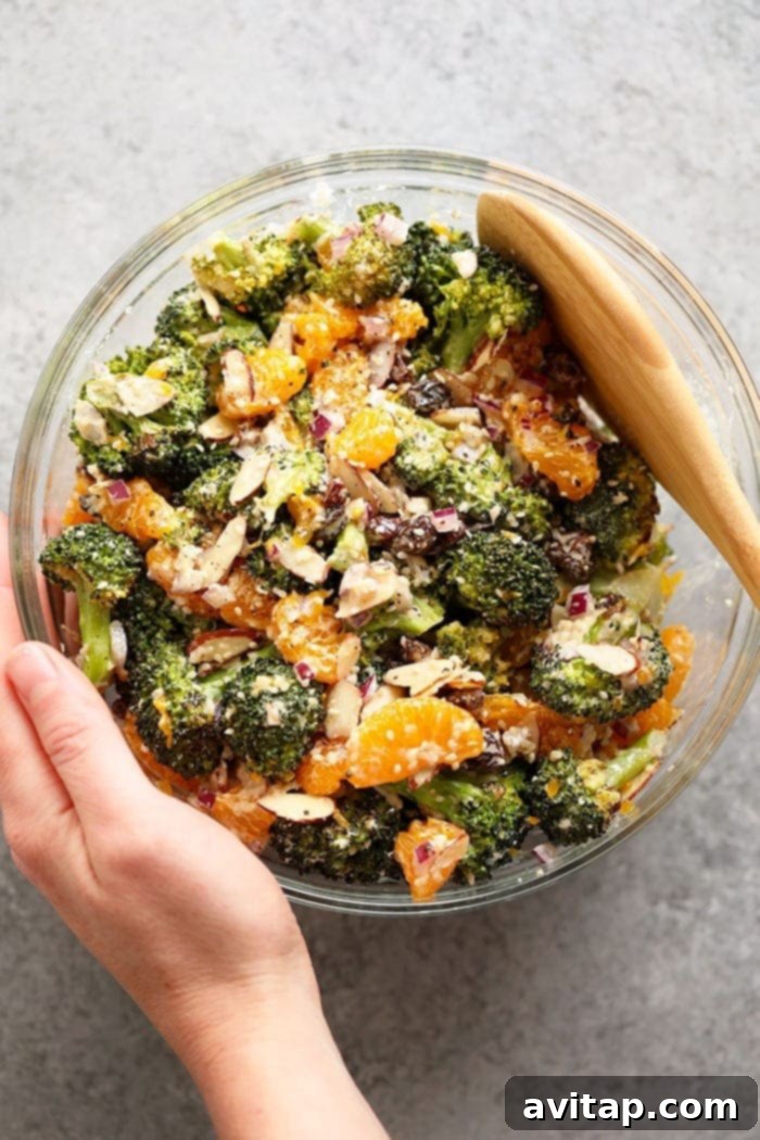 Freshly mixed Asian Broccoli Salad in a bowl, with dressing coating all ingredients.