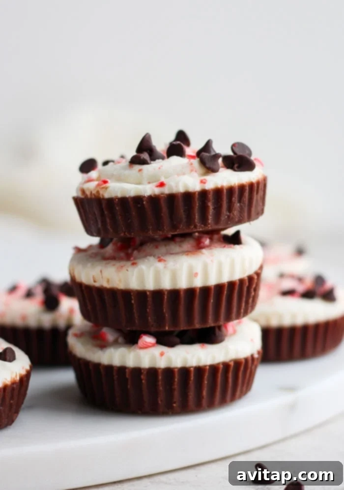 A charming stack of decadent chocolate and peppermint fat bombs, artfully topped with crushed peppermint candy, ready to be enjoyed as a festive and healthy holiday dessert.