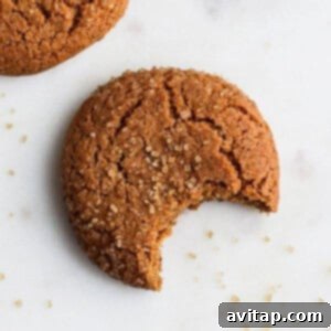 Close-up of freshly baked ginger cookies on a cooling rack, highlighting their beautiful crinkly tops and golden-brown edges.