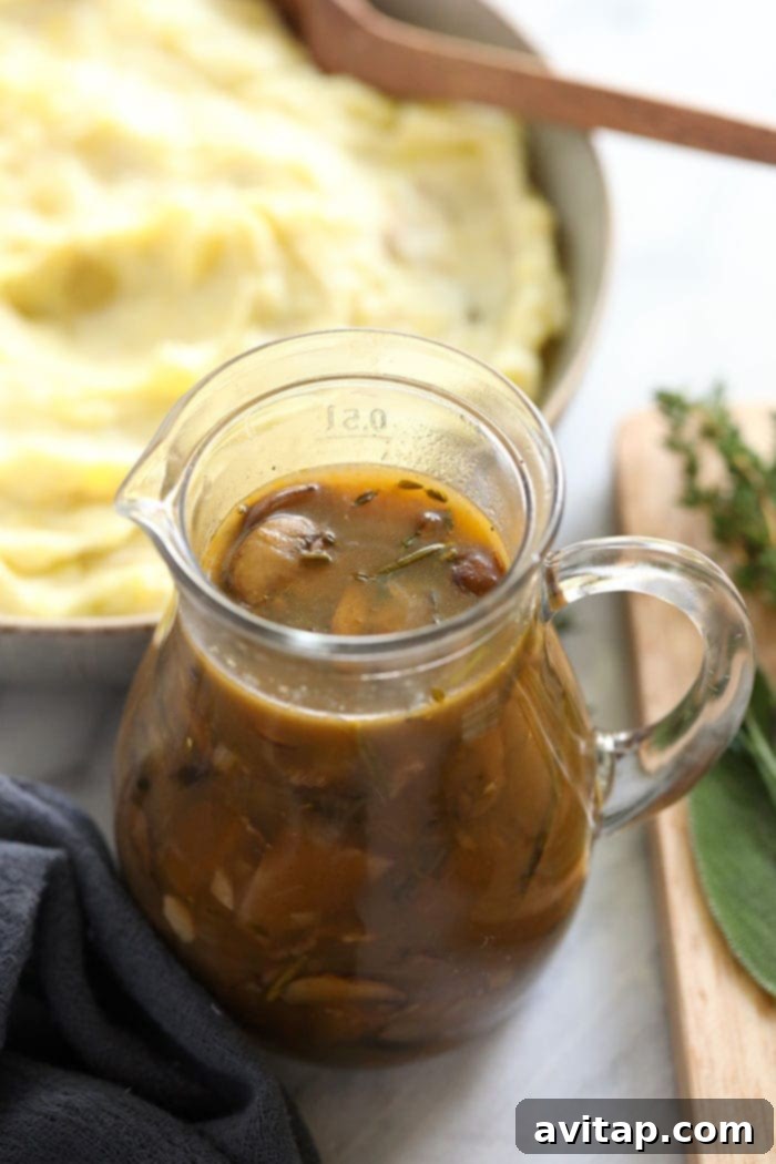 Smooth and rich mushroom gravy beautifully poured into an elegant glass serving jar, ready to be presented at the table.
