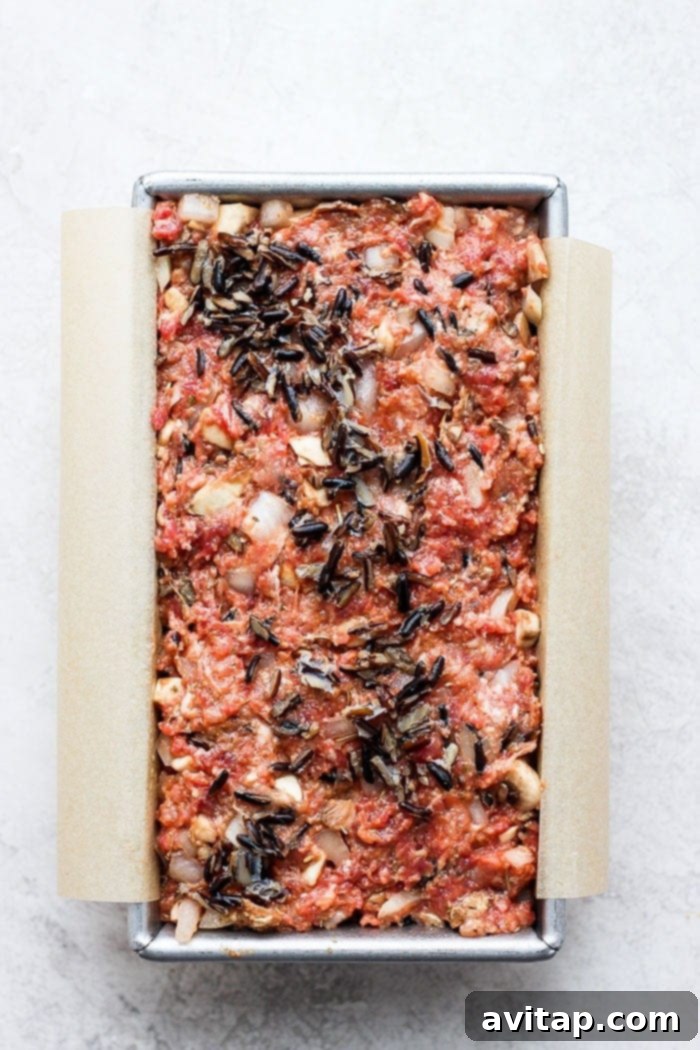 Wild Rice Meatloaf in a loaf pan, expertly shaped and ready for baking