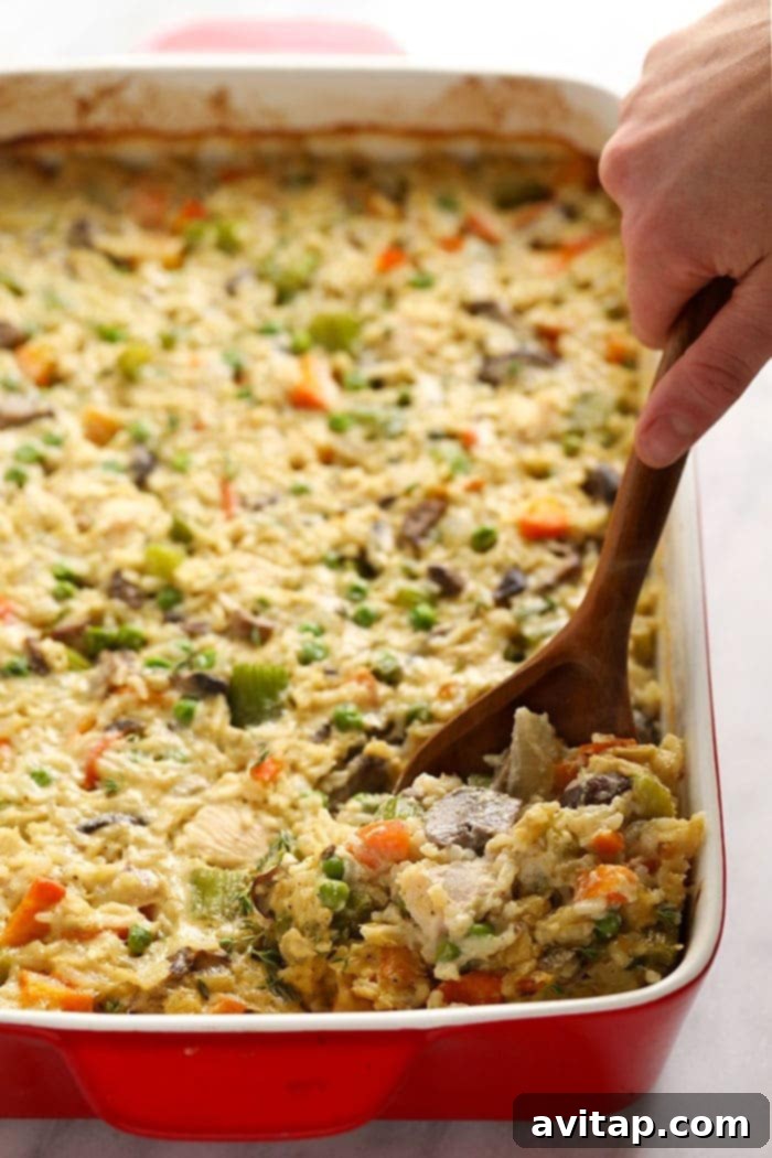 Close-up view of a baked chicken pot pie casserole in a large ceramic dish, showing its golden top and rich filling.