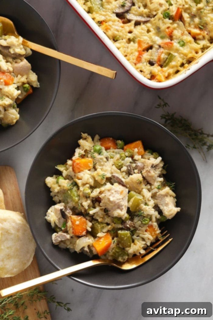An inviting overhead shot of a chicken pot pie casserole in a bowl, garnished with freshly ground black pepper and parsley, ready to be enjoyed.