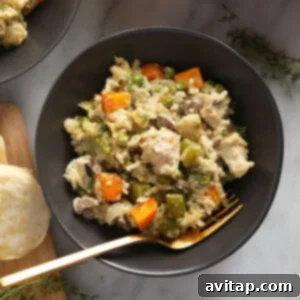 Close-up of a fully baked chicken pot pie casserole in a white dish, ready for serving, with a golden-brown top.