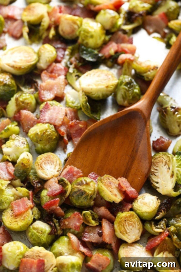 Sheet pan filled with perfectly roasted Brussels sprouts and crispy bacon bits, ready to be served as a delicious holiday side dish.