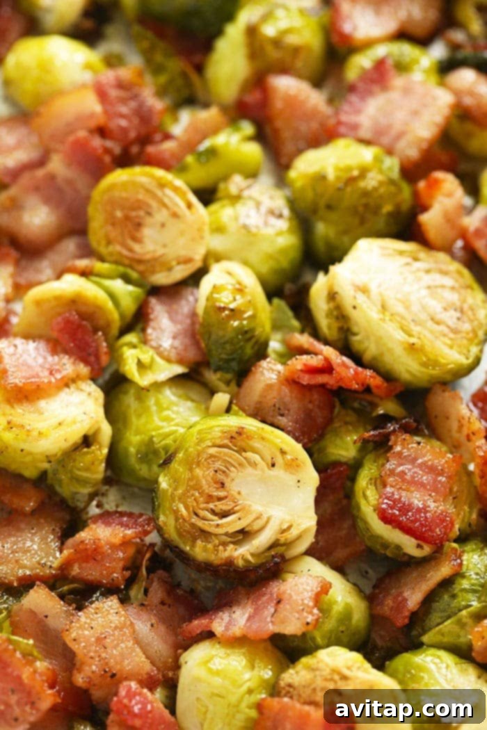 Golden brown roasted Brussels sprouts with crispy bacon bits, a close-up shot of the finished dish ready for serving.