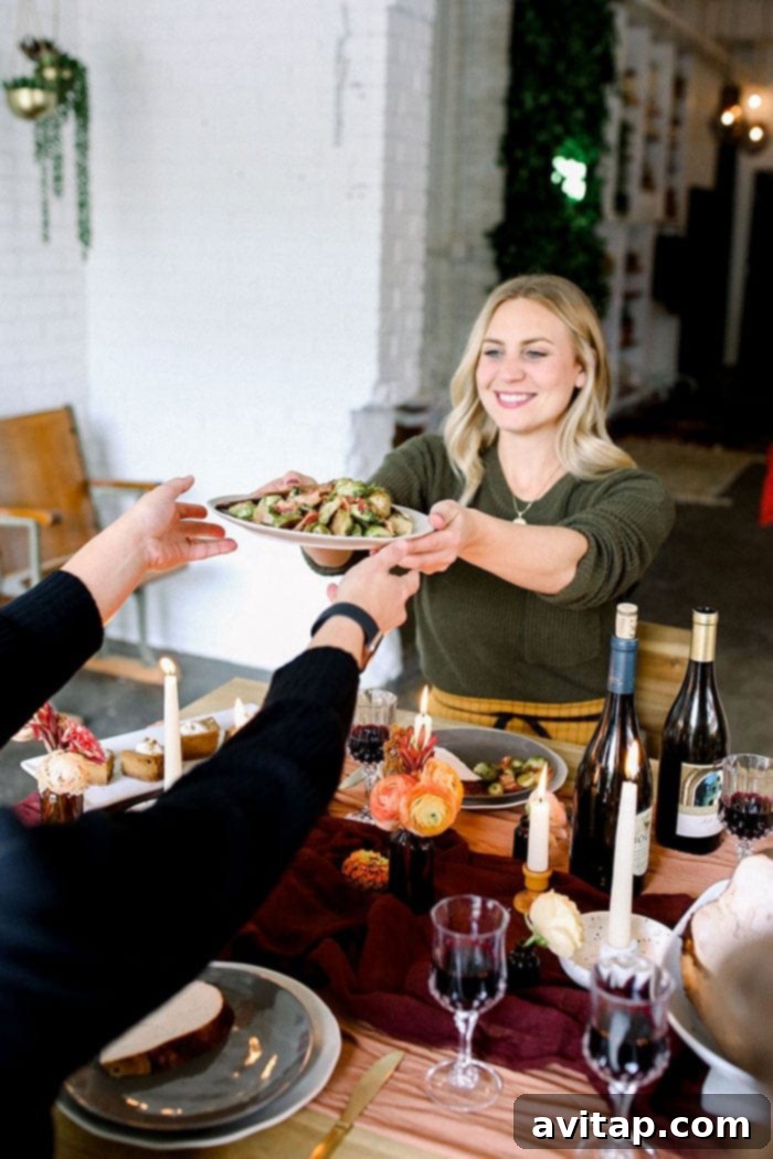 A smiling person holding a bowl of freshly roasted Brussels sprouts with bacon, ready to enjoy.