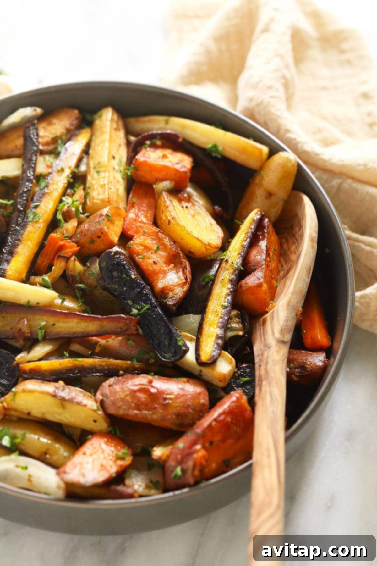 A beautifully presented bowl of roasted root vegetables, garnished with fresh herbs, ready for serving at a festive meal or family dinner.