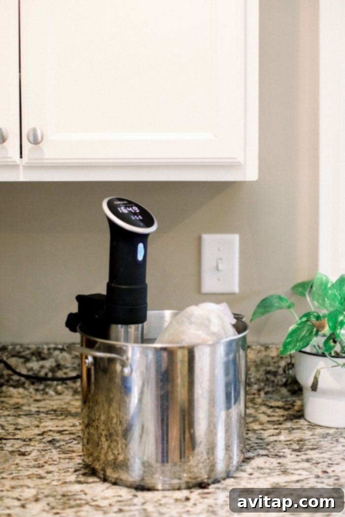 Perfect Sous Vide Turkey 4 A bone-in turkey breast submerged in a water bath with a sous vide immersion circulator maintaining precise temperature.