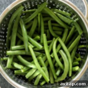 Green beans cooling in a colander after being blanched.