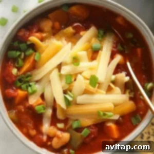 A vibrant bowl of homemade vegetarian chili, topped with fresh cilantro and a dollop of sour cream, showcasing its rich colors and appetizing texture.