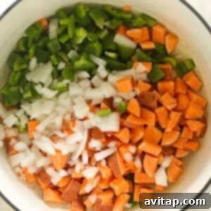 A vegetarian chili with onions and peppers in a white bowl.