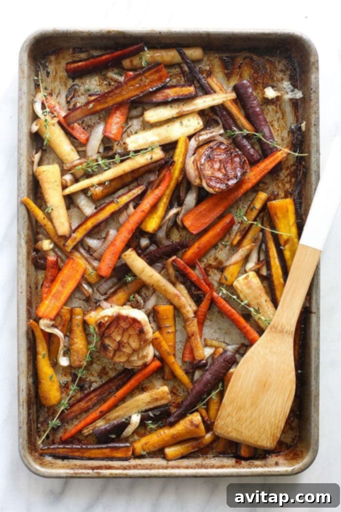 These Honey Balsamic Roasted Carrots are the ultimate holiday side dish! The combination of sweet and savory from the honey balsamic + perfectly roasted carrots, onions and garlic make this side a perfect addition to any holiday table. Deliciously roasted carrots with tender garlic cloves on a baking tray, perfectly golden.