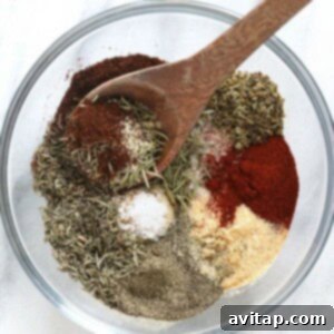 Turkey seasoning ingredients blended in a glass bowl with a spoon.