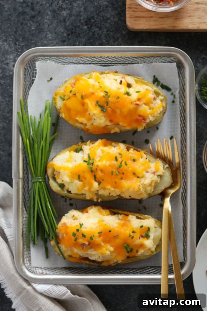 Ultimate Twice Baked Potatoes: Crispy Skins & Creamy Filling Golden-brown twice baked potatoes, perfectly plated and ready to be served, showcasing their crispy skins and rich filling.