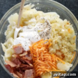 Double-Baked Potato Perfection 3 A large bowl of mashed potato filling, rich with cheese, bacon, and creamy ingredients, ready for stuffing into potato skins.