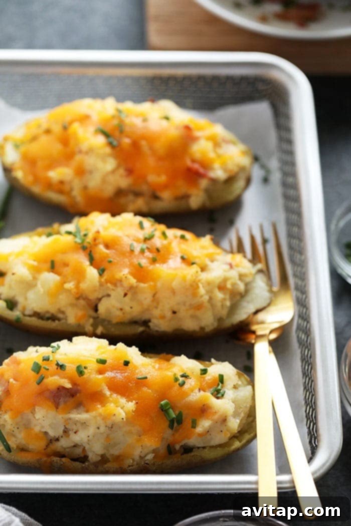 Perfectly Topped Twice Baked Potatoes Ready to Serve A vibrant display of freshly baked twice baked potatoes, garnished with a medley of toppings like bacon, chives, and a dollop of sour cream, artfully arranged on a serving platter.