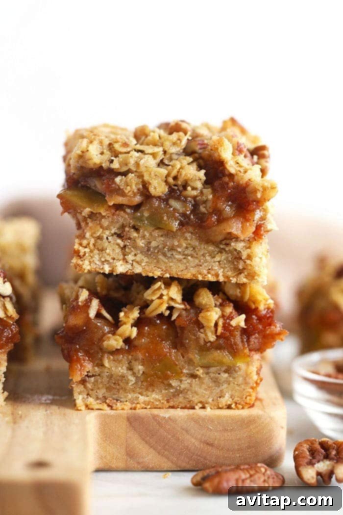 Stacked homemade gluten-free apple pie bars with a golden crust and crumble topping.