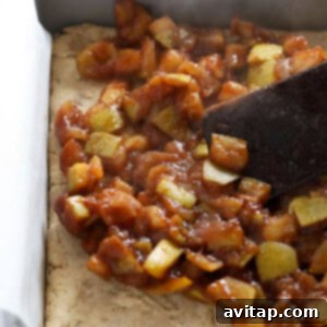 An apple pie bar baked on a baking pan, served with a spatula.