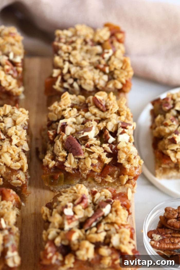 Close-up of apple crumble bars, showcasing the golden crumble and a hint of apple filling on a cutting board.