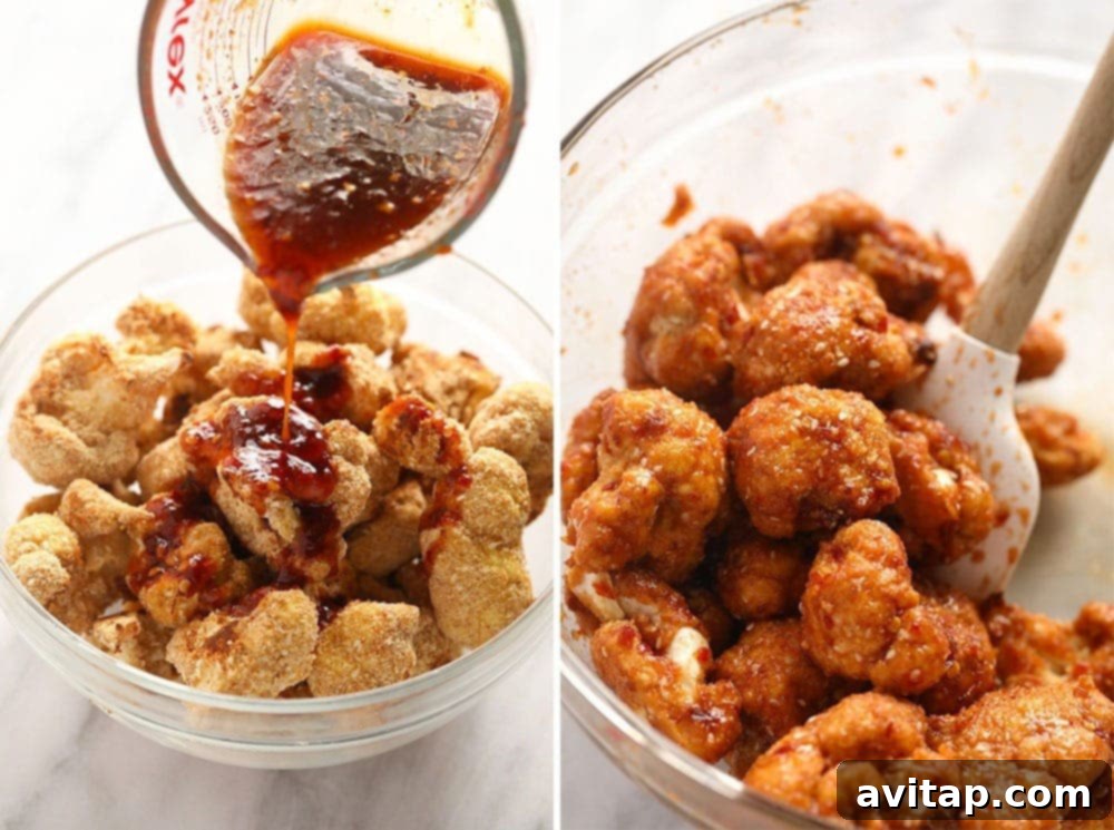 Rich, glossy sweet chili sauce being poured over a bowl of freshly baked cauliflower wings.
