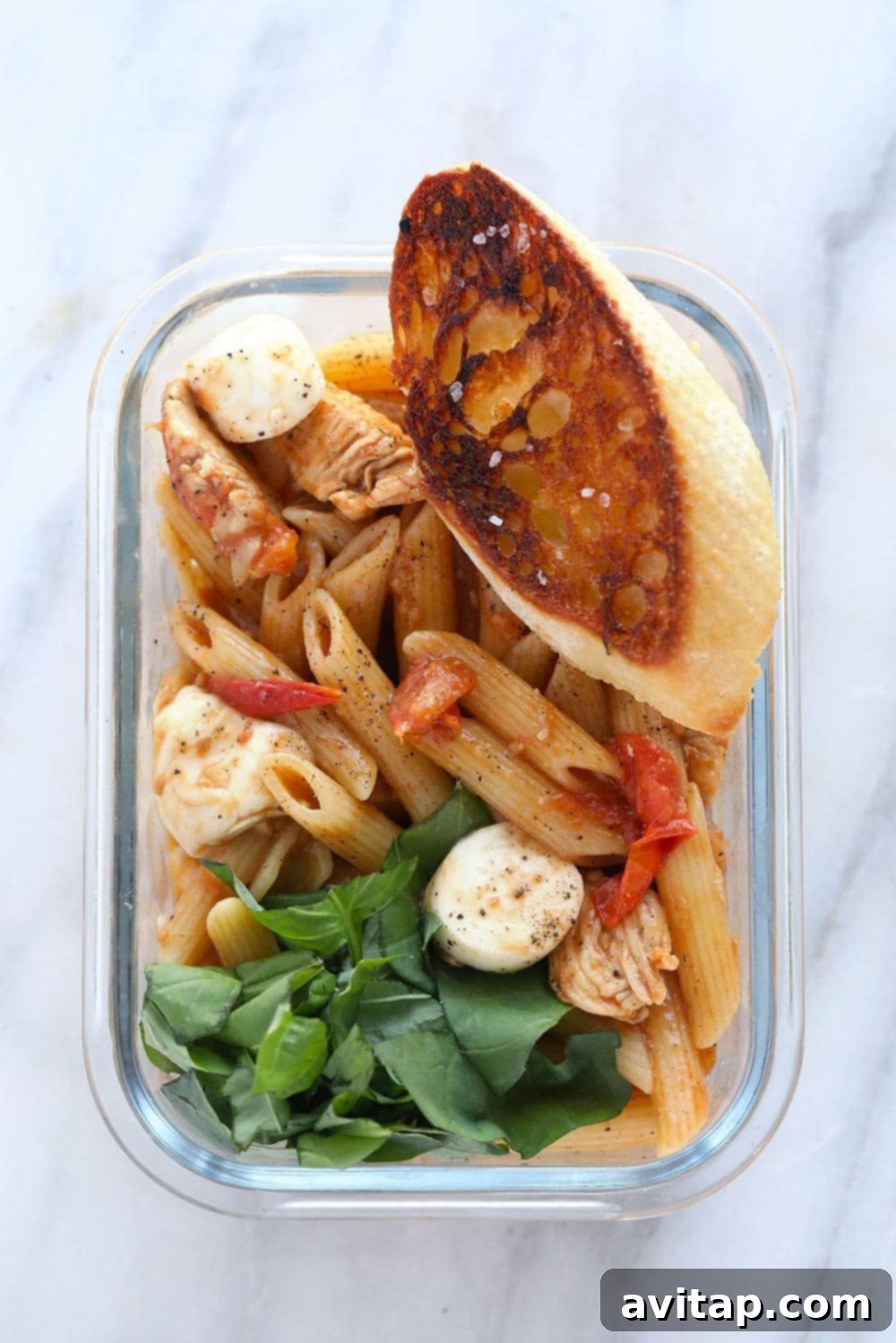 Caprese Chicken Pasta in a meal prep container, ready to eat