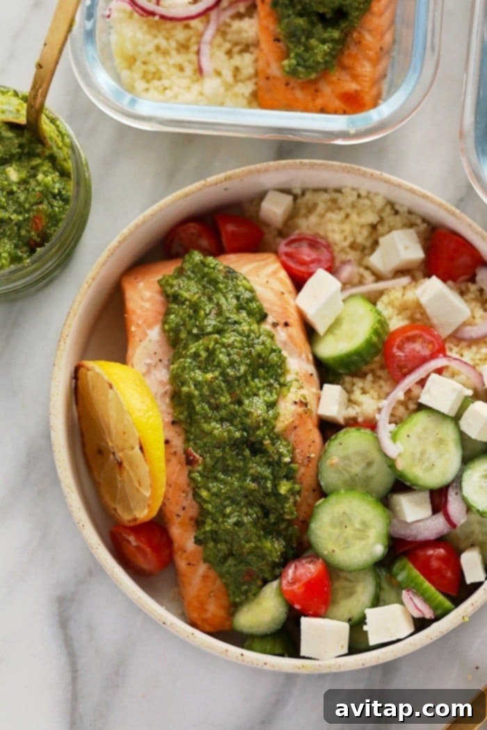 Assembled Salmon Meal Prep Mediterranean Salmon Meal Prep with couscous, Greek salad, and pesto-topped salmon