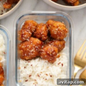 General Tso's Cauliflower and rice in a meal prep container, topped with sesame seeds