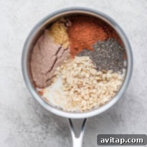 Decadent Chocolate Protein Oats 3 Protein-packed oatmeal with chia seeds and other ingredients in a pot before cooking.