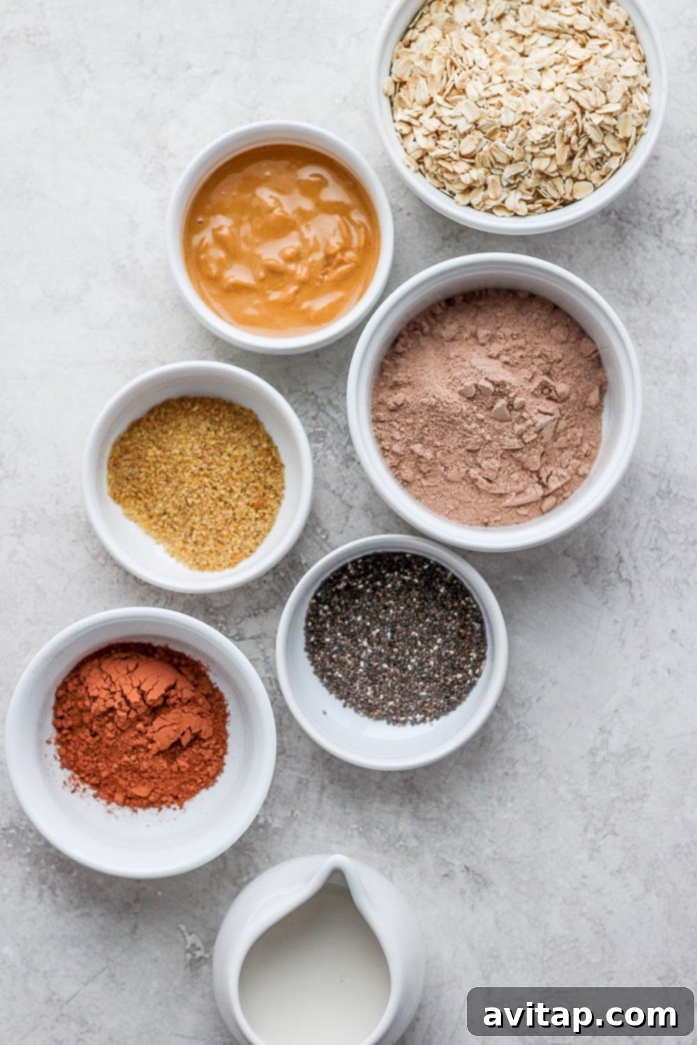 All the ingredients you need for your delicious Chocolate Sea Salt Protein Oatmeal, laid out beautifully. A beautiful display of all the individual ingredients for chocolate sea salt protein oatmeal in small bowls, ready for preparation.