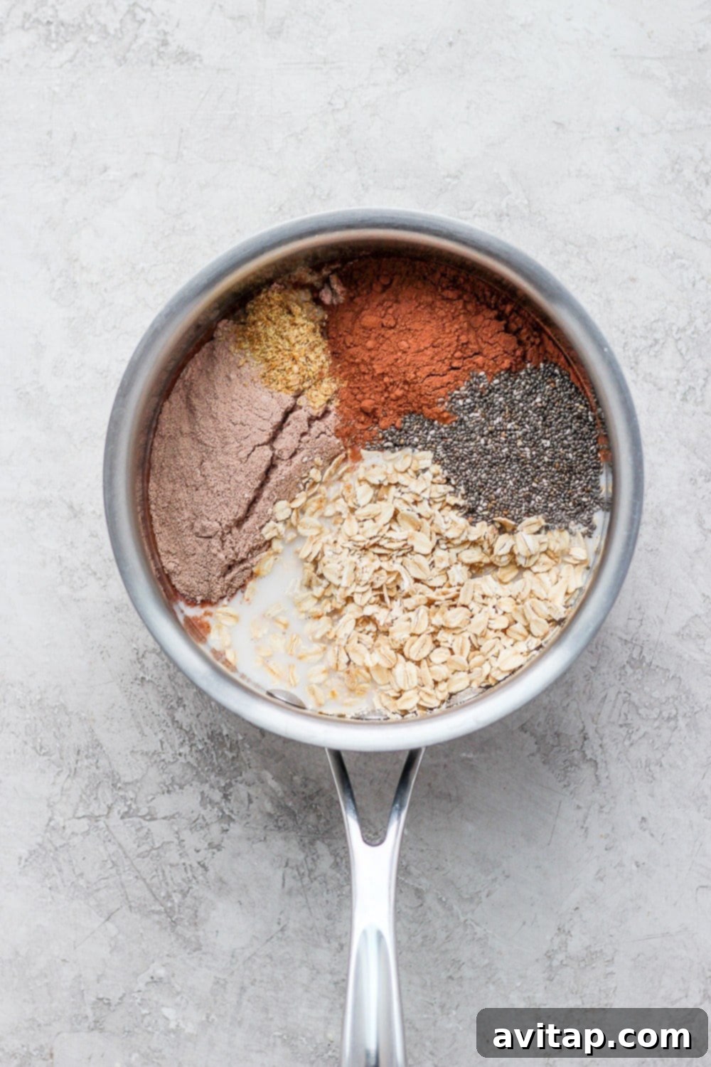 Ingredients for your delicious Chocolate Sea Salt Protein Oatmeal, all in one pot, ready to cook. All the ingredients for chocolate sea salt protein oatmeal are in a pot, ready to be cooked on the stovetop.