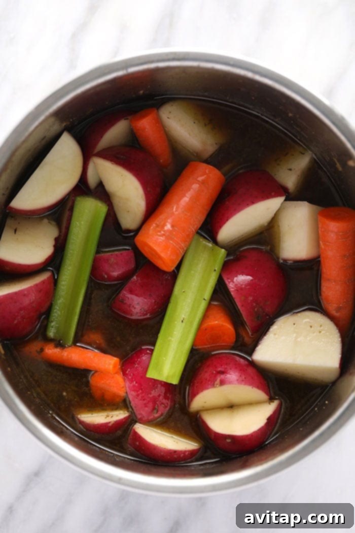 Pot roast vegetables including carrots, celery, and red potatoes ready for pressure cooking in the Instant Pot