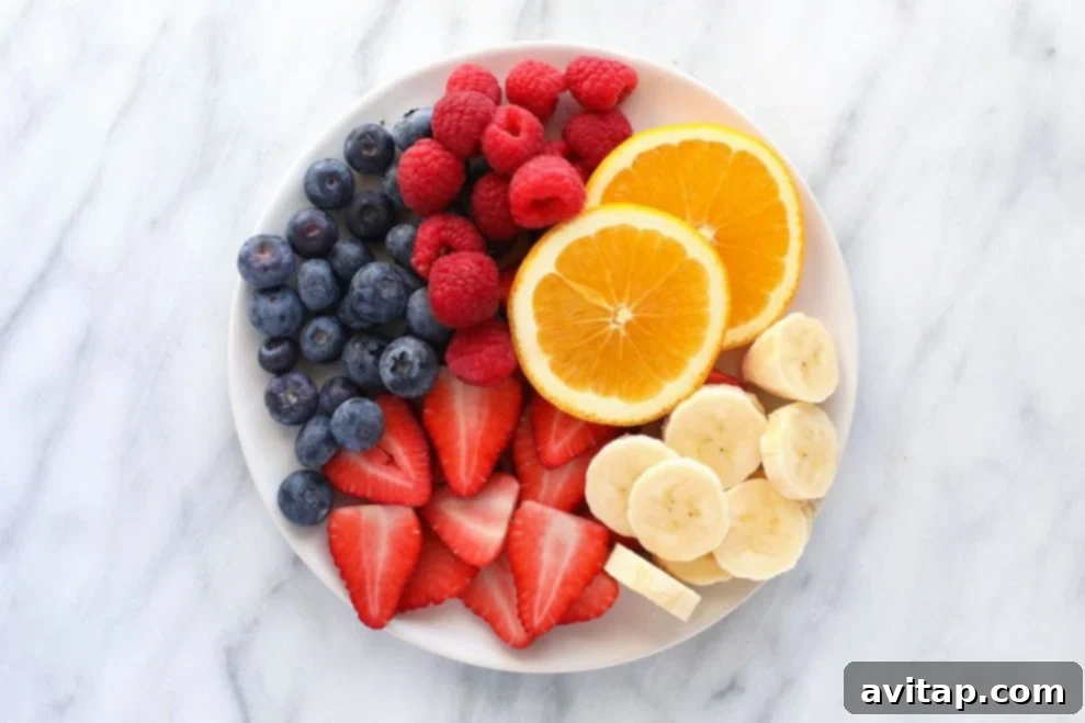 A colorful plate featuring a vibrant assortment of fresh fruits, including berries and kiwi, perfect for a healthy diet.